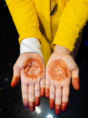 Intricate bridal mehndi design on both hands during mehndi ceremony