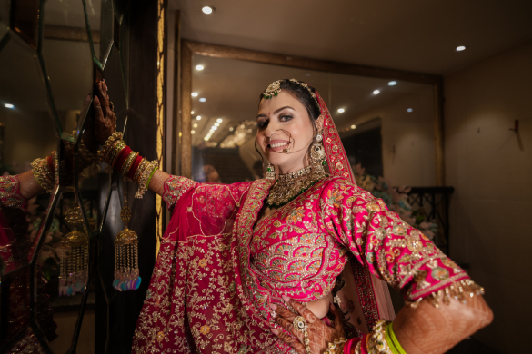 Bride dancing joyfully in red lehenga during wedding festivities