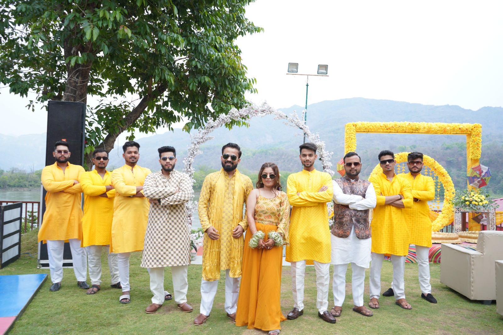 a group of people standing together in yellow outfits- haldi photography